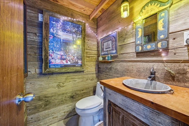 bathroom with wood ceiling, vanity, wooden walls, beamed ceiling, and toilet