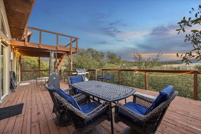 deck at dusk featuring area for grilling