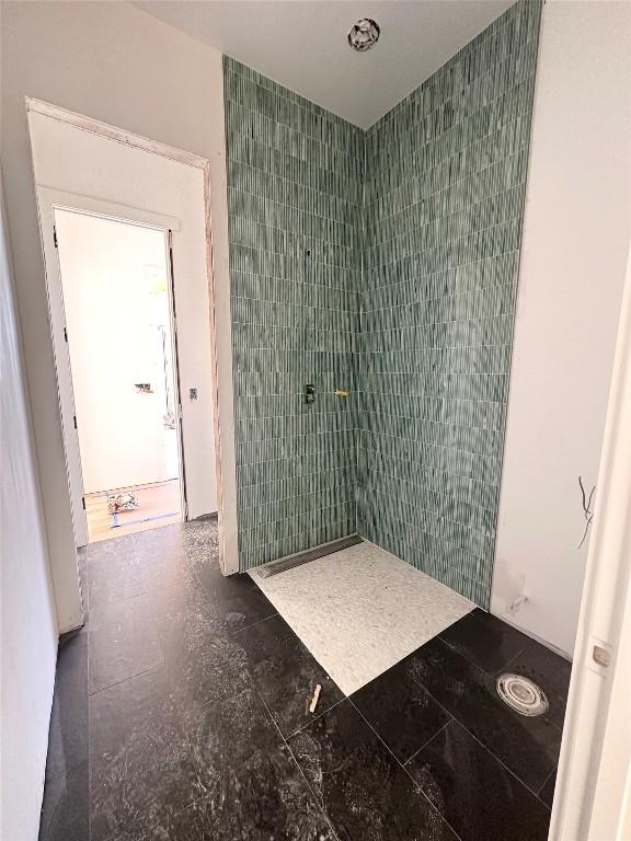 bathroom featuring a shower and tile walls