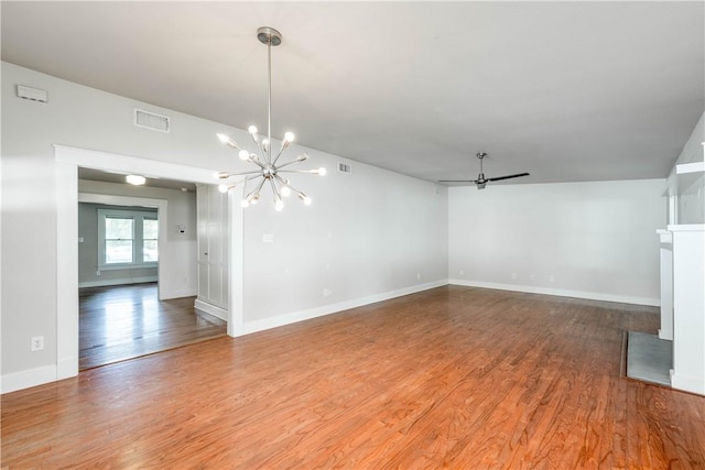 unfurnished living room featuring hardwood / wood-style floors and ceiling fan with notable chandelier