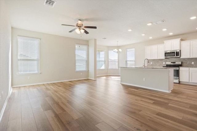 kitchen with open floor plan, stainless steel appliances, visible vents, and light wood-style floors