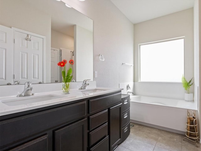 bathroom with double vanity, a sink, a bath, and tile patterned floors