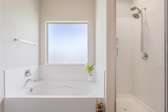 bathroom with a stall shower and a garden tub