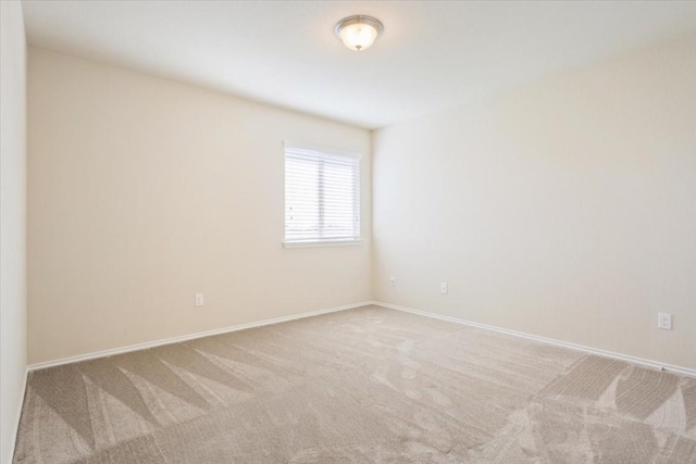 empty room featuring baseboards and carpet flooring