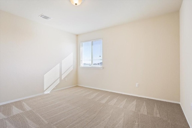 carpeted empty room with visible vents and baseboards