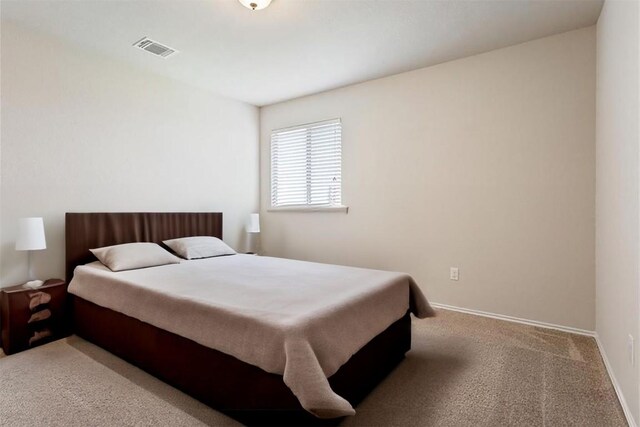 carpeted bedroom featuring visible vents and baseboards