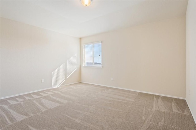 unfurnished room with baseboards and light colored carpet