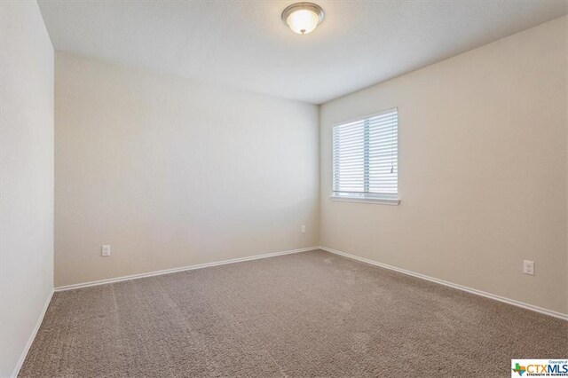 carpeted spare room with baseboards