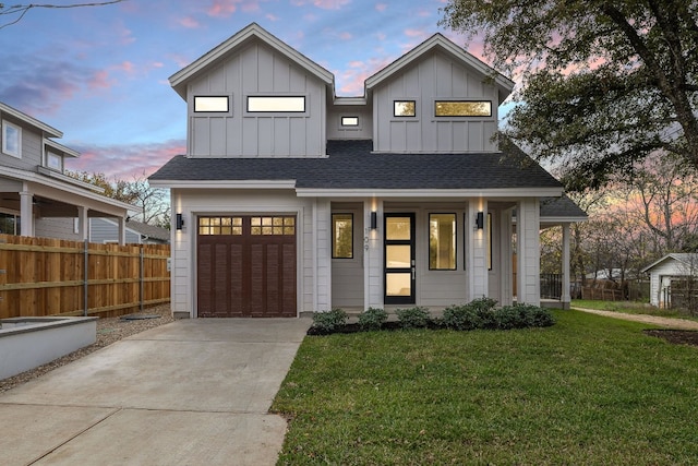 view of front of property featuring a yard, covered porch, and a garage