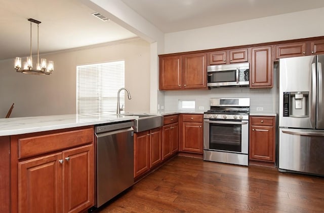 kitchen featuring sink, stainless steel appliances, dark hardwood / wood-style floors, a notable chandelier, and decorative backsplash