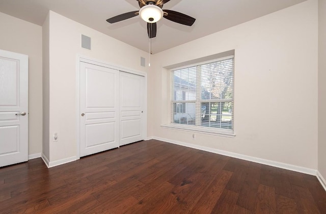 unfurnished bedroom featuring dark hardwood / wood-style flooring, ceiling fan, and a closet