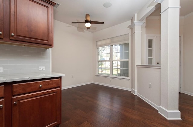 kitchen featuring backsplash, decorative columns, ceiling fan, and dark wood-type flooring