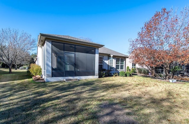 rear view of property with a sunroom and a yard