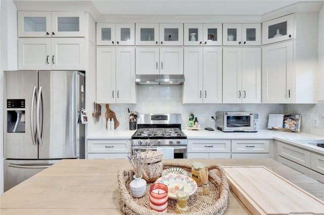 kitchen featuring tasteful backsplash, white cabinets, and stainless steel appliances