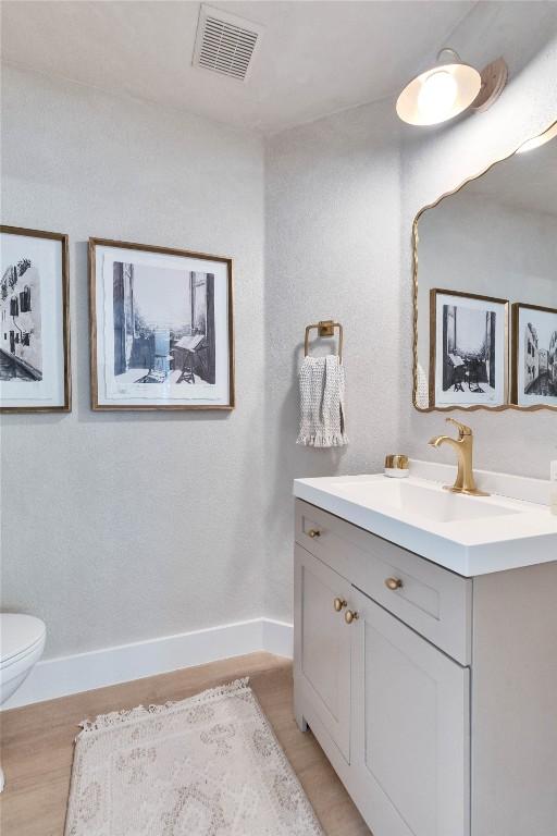 bathroom featuring hardwood / wood-style floors, toilet, and vanity