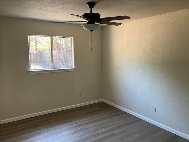 empty room featuring ceiling fan and dark hardwood / wood-style flooring