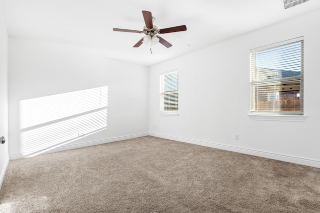 spare room with carpet, ceiling fan, and a wealth of natural light