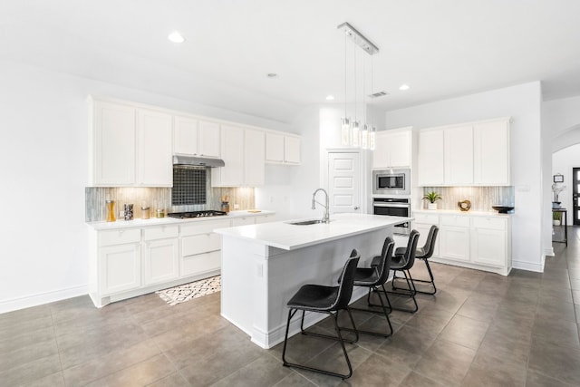 kitchen featuring a center island with sink, white cabinets, sink, and appliances with stainless steel finishes