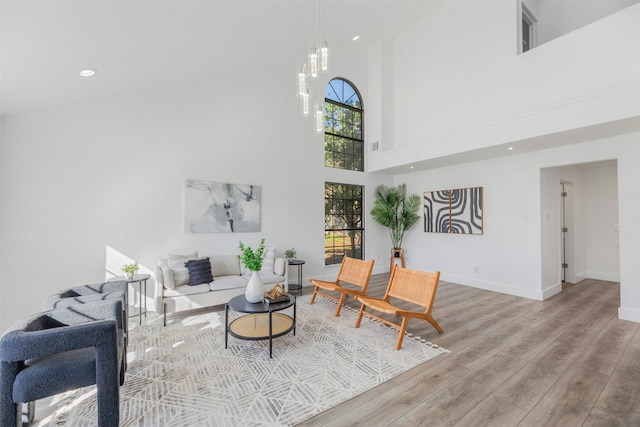 living room featuring light hardwood / wood-style floors and a high ceiling