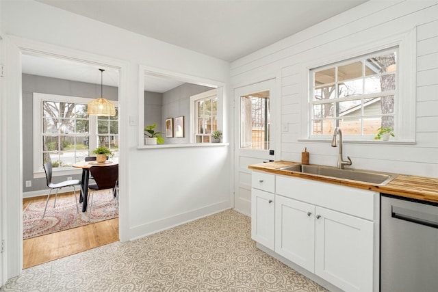 bar with dishwasher, sink, white cabinets, and pendant lighting