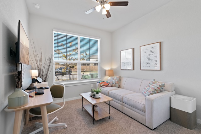 carpeted living area with a ceiling fan and baseboards