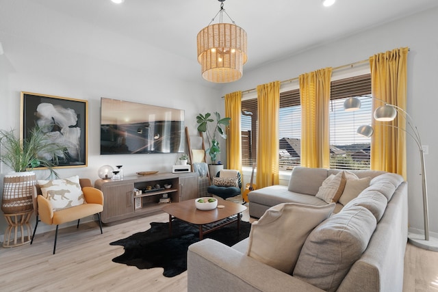 living area featuring baseboards, recessed lighting, wood finished floors, and a notable chandelier