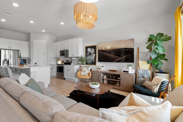 living room featuring recessed lighting, visible vents, light wood-style flooring, and an inviting chandelier