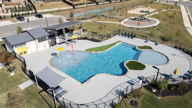 pool featuring a patio area, fence, and a water play area