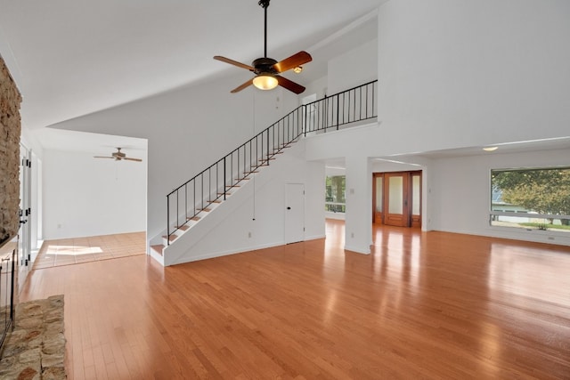 unfurnished living room featuring light hardwood / wood-style flooring, high vaulted ceiling, and ceiling fan