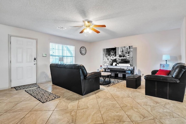 tiled living room with ceiling fan and a textured ceiling