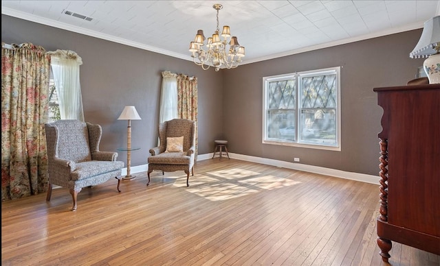 sitting room with ornamental molding, light hardwood / wood-style floors, plenty of natural light, and a notable chandelier