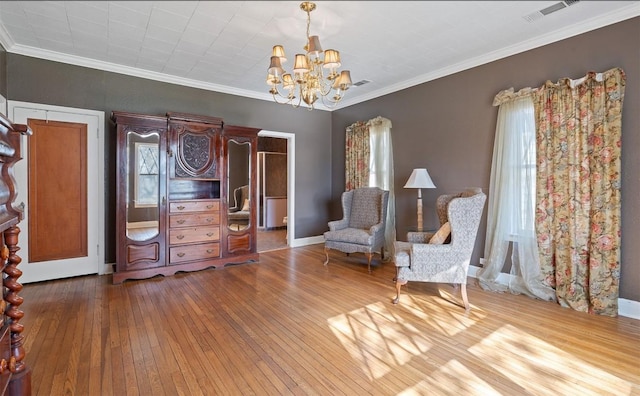 unfurnished room with wood-type flooring, ornamental molding, and an inviting chandelier