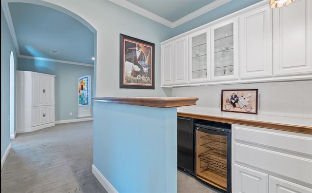 bar featuring white cabinets, light carpet, and beverage cooler