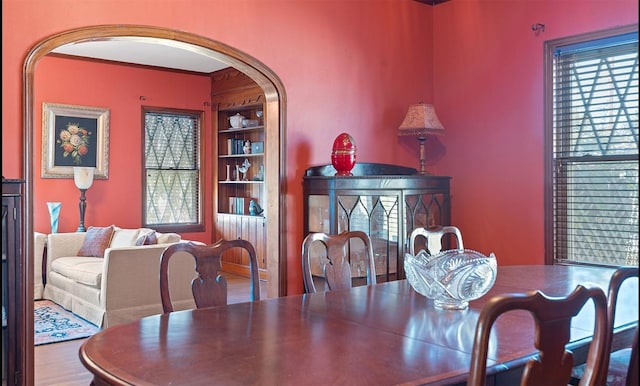 dining space with hardwood / wood-style flooring and built in features