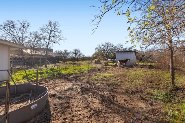 view of yard with a rural view and a storage shed