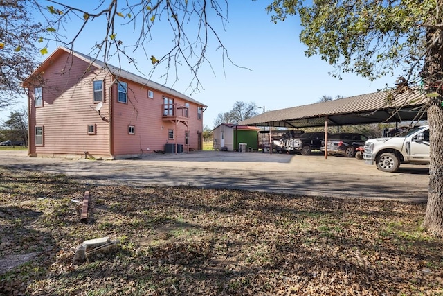 view of property exterior featuring central air condition unit and a carport