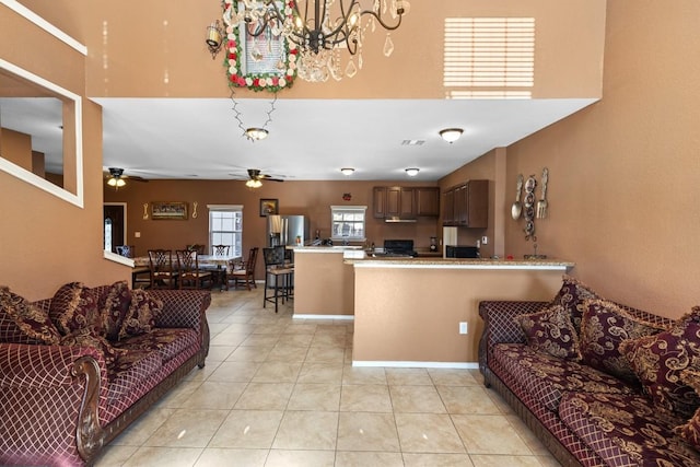 living room with ceiling fan with notable chandelier and light tile patterned flooring