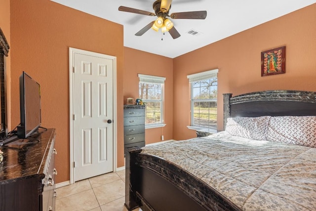 tiled bedroom featuring ceiling fan