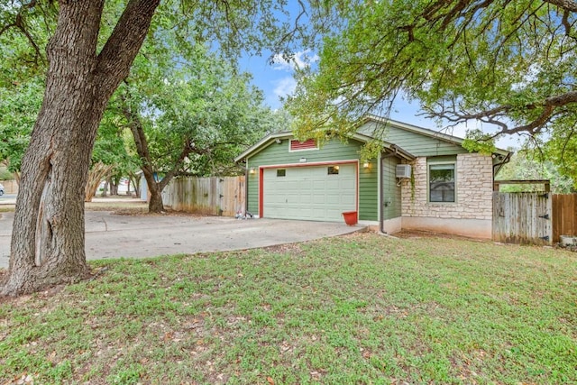 view of front of house featuring a wall mounted air conditioner, a front yard, and a garage