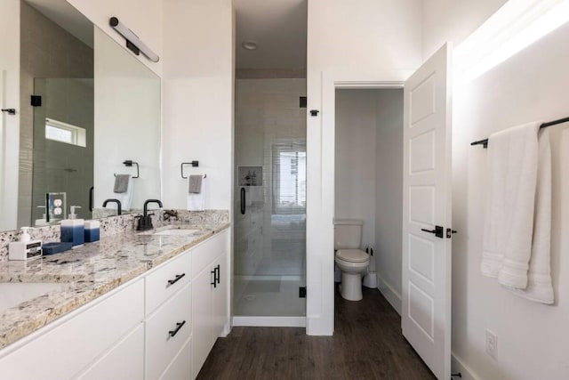 bathroom with vanity, wood-type flooring, an enclosed shower, and toilet