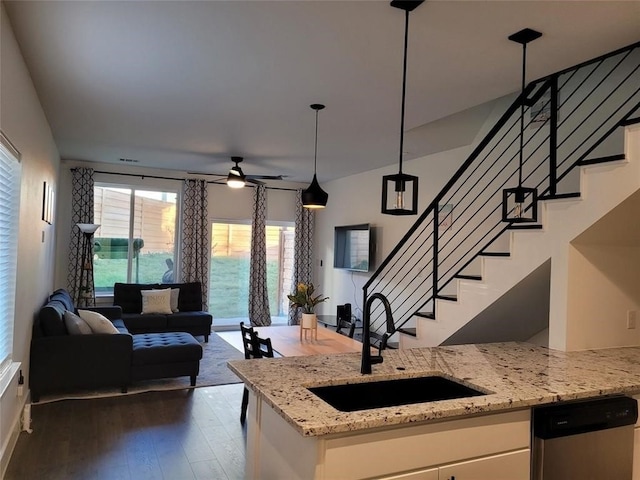 kitchen with white cabinetry, dishwasher, sink, hanging light fixtures, and light stone counters