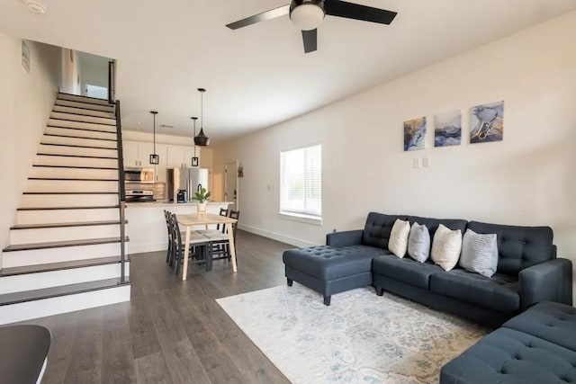 living room featuring ceiling fan and dark hardwood / wood-style floors