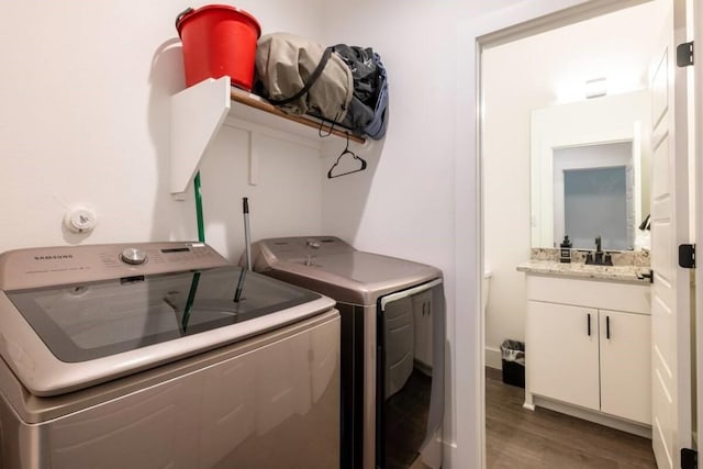 laundry area with washer and clothes dryer, dark hardwood / wood-style floors, and sink