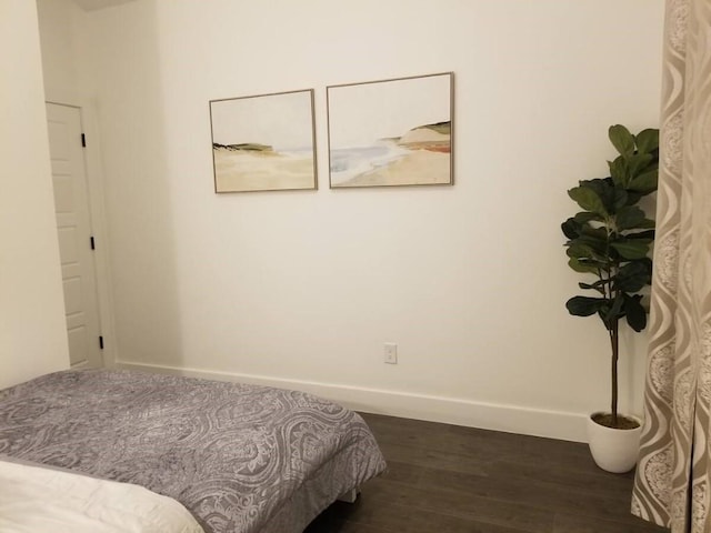 bedroom with dark hardwood / wood-style floors