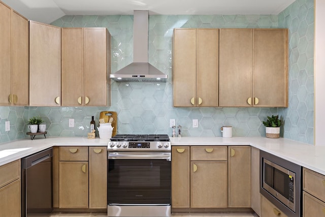 kitchen featuring wall chimney range hood, light brown cabinetry, appliances with stainless steel finishes, and tasteful backsplash