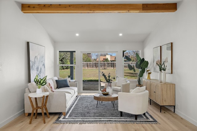 living room featuring lofted ceiling with beams and light hardwood / wood-style flooring