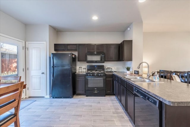 kitchen with black appliances, dark brown cabinetry, kitchen peninsula, and sink