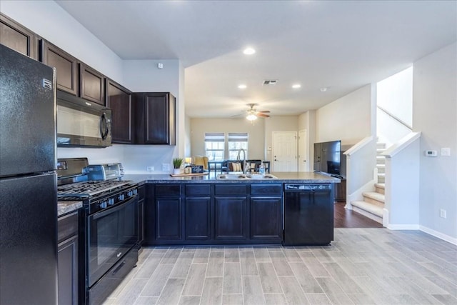 kitchen featuring dark brown cabinetry, ceiling fan, sink, kitchen peninsula, and black appliances