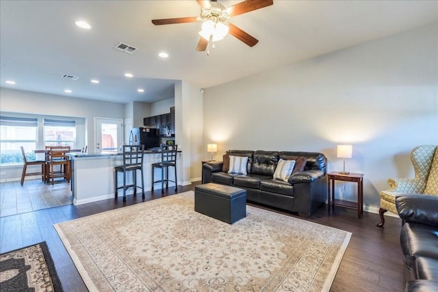 living room featuring dark hardwood / wood-style flooring and ceiling fan