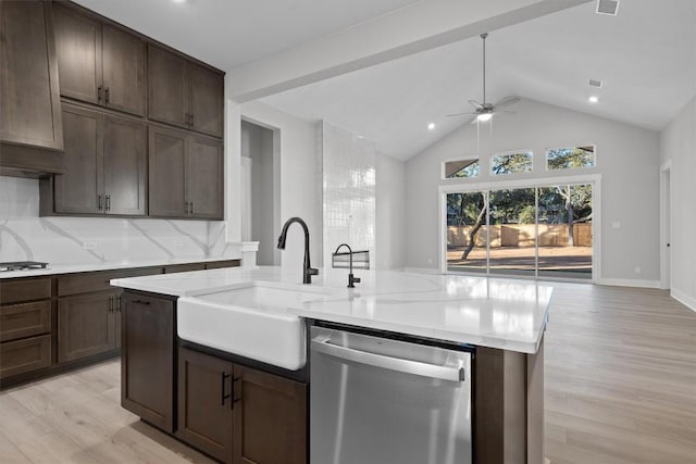 kitchen with backsplash, sink, stainless steel dishwasher, light hardwood / wood-style floors, and light stone counters